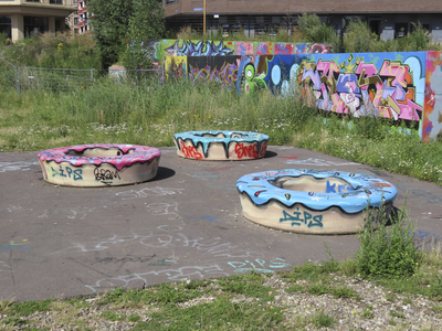 901822 Afbeelding van enkele met graffiti bespoten ronde betonnen zitelementen op de tijdelijke graffitivrijplaats ('De ...